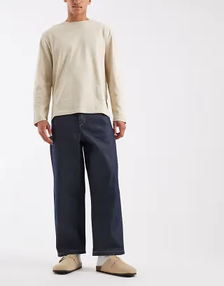 ASOS DESIGN relaxed tapered jeans in raw denim with pleats and buckle