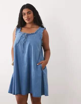 ASOS DESIGN Curve denim ruffle detail mini dress with pockets in mid blue