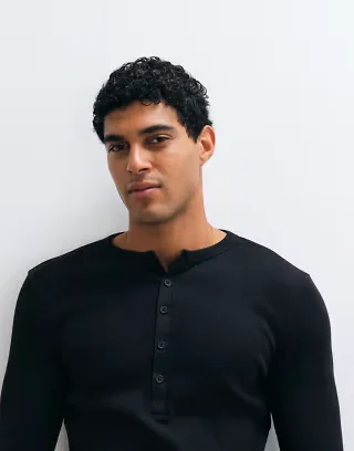 ASOS DESIGN muscle fit long sleeve t-shirt with woven henley neck in black rib knit